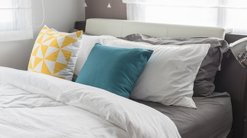 colorful pillows on white bed in modern bedroom